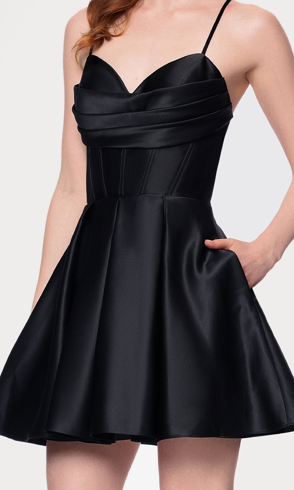 A woman wearing the Lace-Up Short Hoco Dress (Blondie Nites 4578BN), a sleeveless black satin junior cocktail dress with a fitted bodice, flared skirt, and pockets.